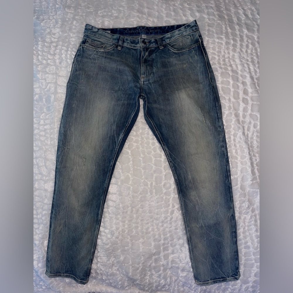 Calvin Klein Menswear blue wash distressed jeans. Size (W33-L30).